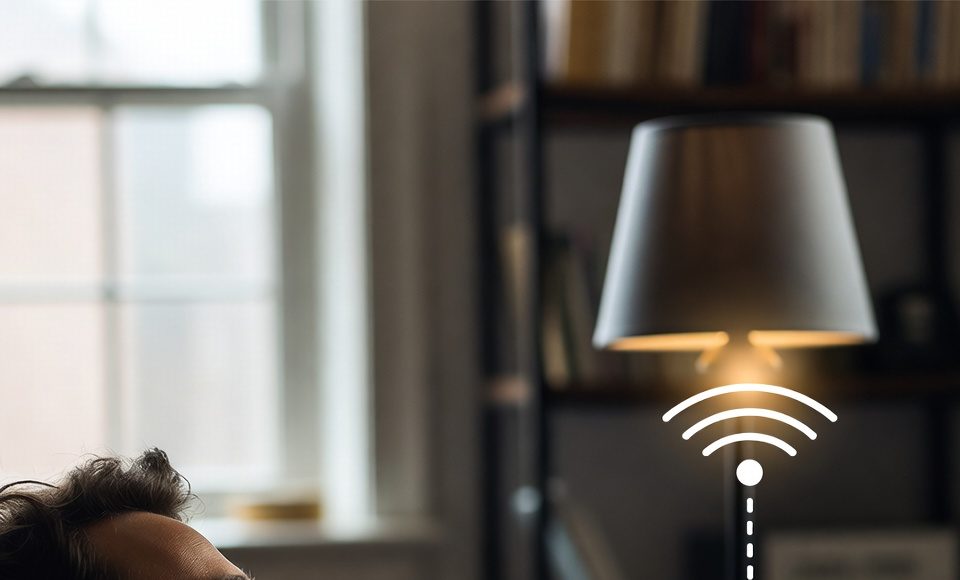 A person using a voice command with a smart speaker to control a lamp connected to a smart plug.