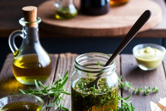 Перестаньте купувати ці 10 речей: Прості альтернативи, які можна зробити своїми руками та заощадити гроші. 💰✨ Домашня заправка для салату в баночці зі свіжими інгредієнтами, такими як оливкова олія та зелень.