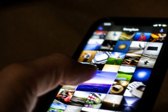 10 ukrytych funkcji iPhone'a, które sprawią, że poczujesz się jak geniusz techniczny Palec zaznaczający wiele zdjęć iPhone'a jednocześnie poprzez przeciągnięcie po przekątnej ekranu.