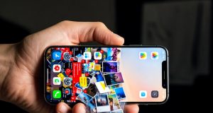 Dijital Dağınıklık: Telefonunuzu Nasıl Düzenleyebilir ve Haftada 5 Saatinizi Nasıl Geri Kazanabilirsiniz? ⏳📱 Telefon tutan bir el ve ekrandan silinen fotoğraflardan oluşan bir şelale