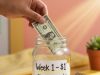 The 52-Week Money Challenge: Save Over $1,300 With This Simple Trick.💰📅 Starting the 52-Week Money Challenge by placing the first dollar into a savings jar.